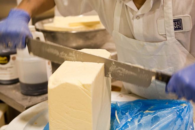 Photo of Sweet Sam's Worker Cutting a Block of Butter